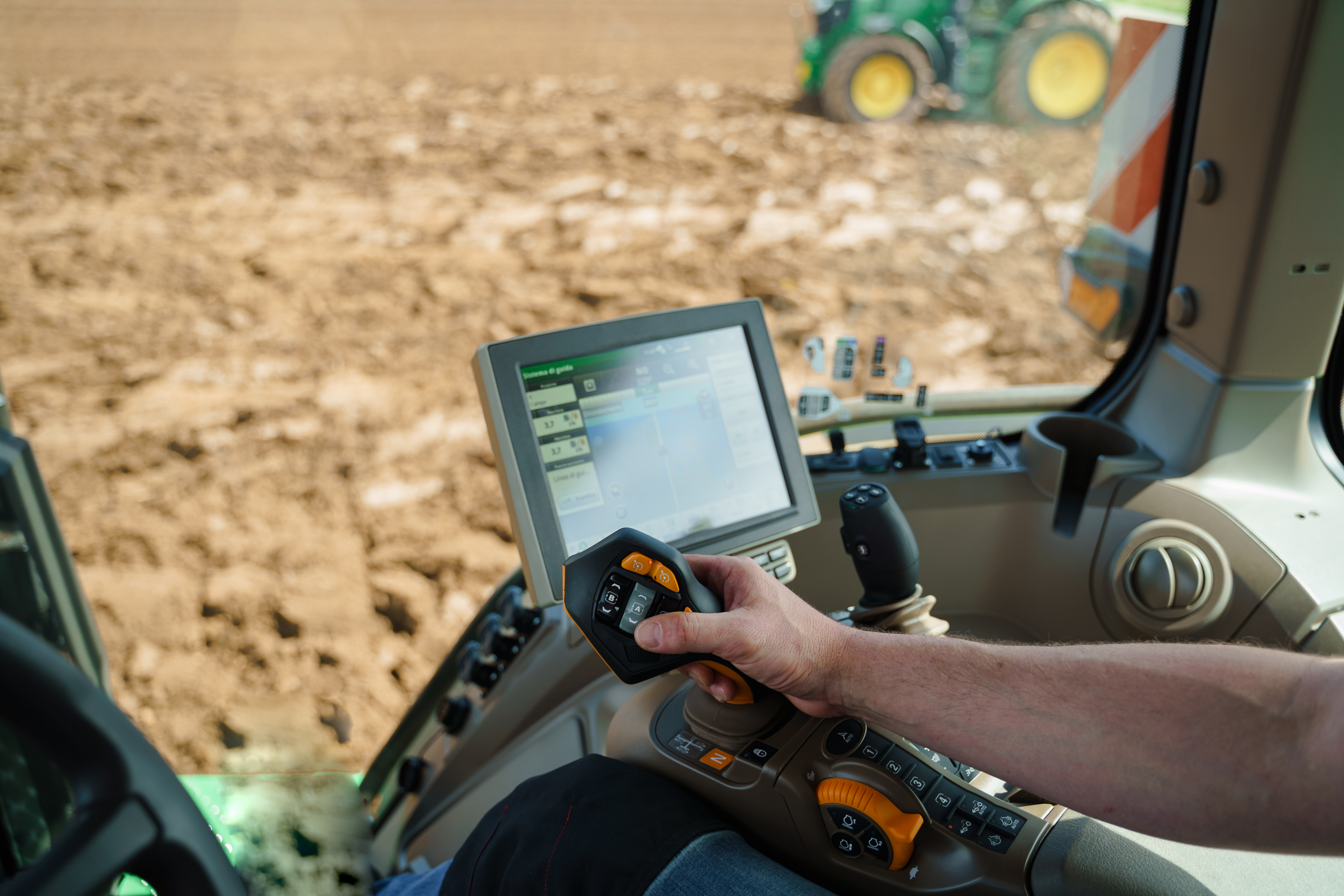 Operator using a modern agricultural machine with a digital HMI in the field