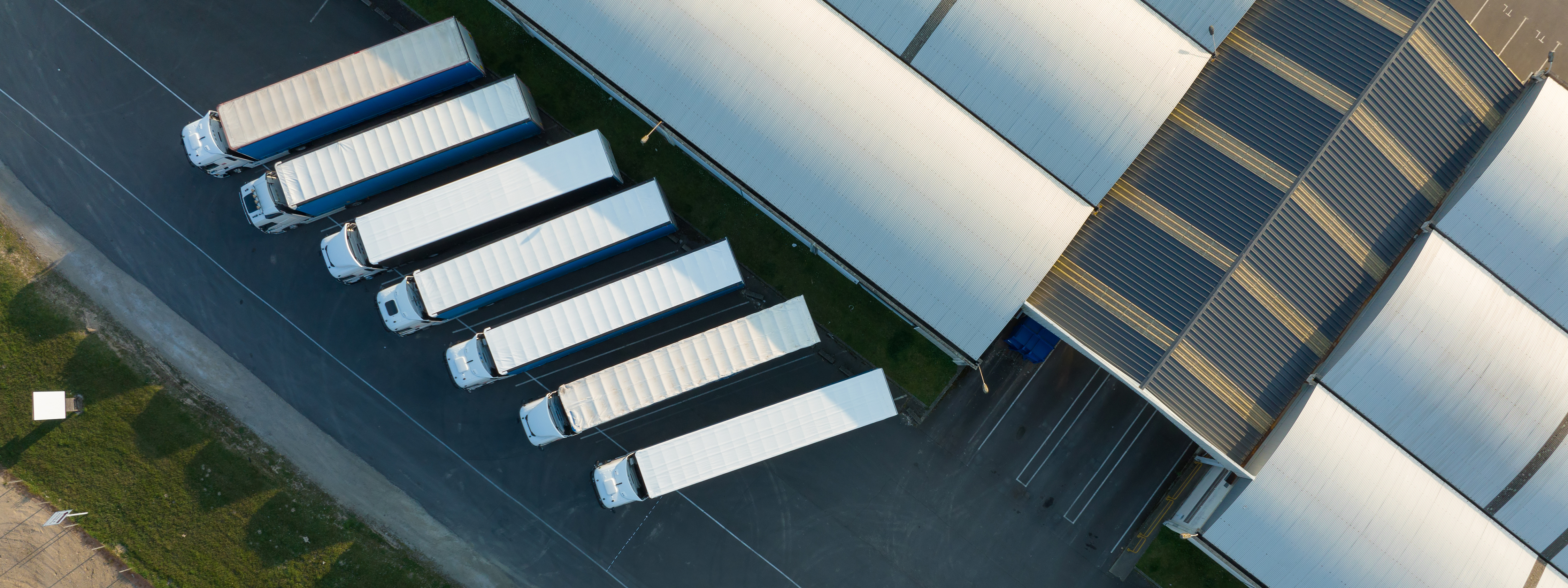 Luftaufnahme eines Logistikzentrums mit Lagerhallen und Verkehrsflächen