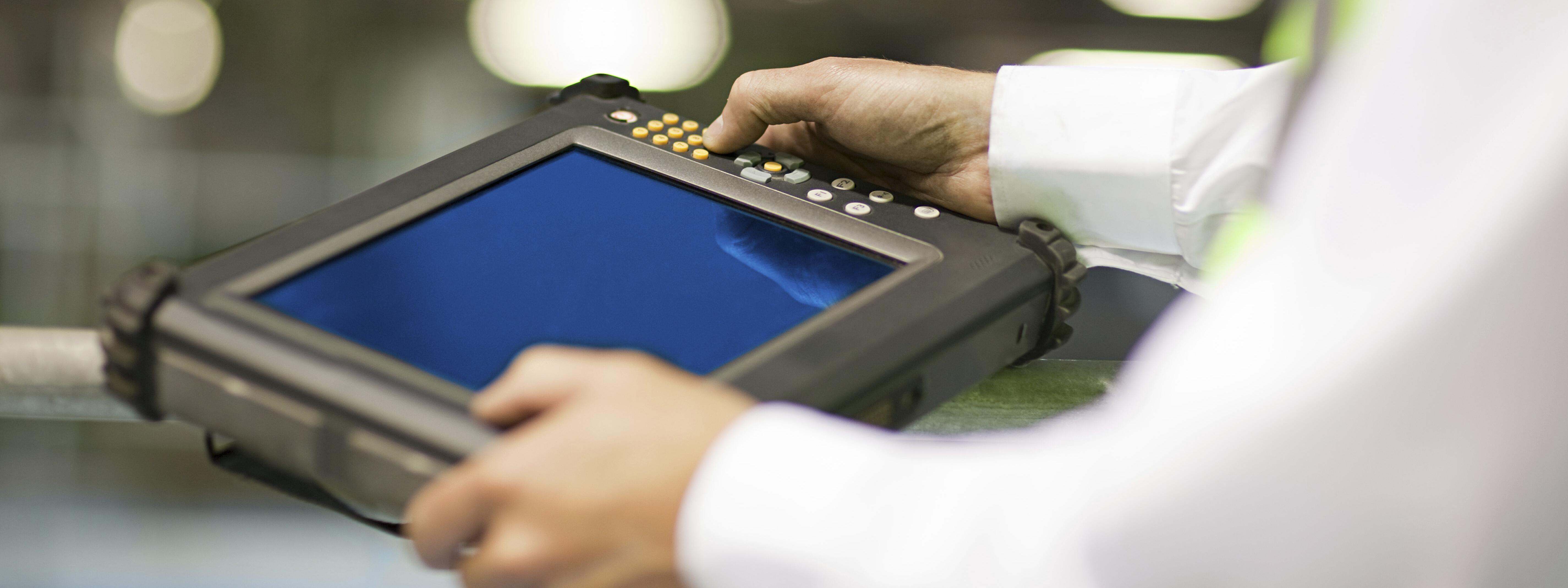 Mitarbeiter nutzt ein Tablet an einem industriellen Arbeitsplatz